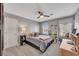 Well-lit bedroom featuring a desk, shelves, a ceiling fan, and two windows at 4950 Willow Creek Dr, Woodstock, GA 30188