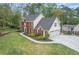 A two-story brick home with an attached three-car garage, neat landscaping, and a well-manicured lawn at 4950 Willow Creek Dr, Woodstock, GA 30188