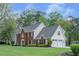 Spacious two-story home with a brick facade and a two-car garage, surrounded by lush greenery at 4950 Willow Creek Dr, Woodstock, GA 30188