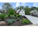 Beautifully landscaped yard with lush greenery leading to a two-story home with a two-car garage at 4950 Willow Creek Dr, Woodstock, GA 30188