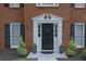 Elegant front door with decorative trim, flanked by sconces and manicured greenery, enhancing curb appeal at 4950 Willow Creek Dr, Woodstock, GA 30188