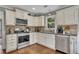 Updated kitchen features stainless steel appliances, granite countertops, and tile backsplash at 4950 Willow Creek Dr, Woodstock, GA 30188