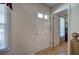 Entryway hallway with a view of a white paneled front door and laminate wood flooring at 105 Whisper Way, Dacula, GA 30019