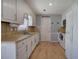 Galley kitchen featuring white cabinetry, stainless sink, and laminate wood flooring at 105 Whisper Way, Dacula, GA 30019