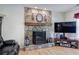 Living room with stone fireplace and hearth, wood mantle, and modern TV stand and laminate wood floor at 105 Whisper Way, Dacula, GA 30019
