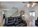 Open-concept living room with ceiling fan, view of staircase, and dining area with laminate wood flooring at 105 Whisper Way, Dacula, GA 30019