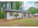 Beautifully renovated white brick house featuring dark trim, a lovely porch, and a lush front yard at 2190 Highview Rd, Atlanta, GA 30311