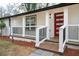 Close-up of a front porch featuring white railings, a striking red door, and well-maintained landscaping at 2190 Highview Rd, Atlanta, GA 30311