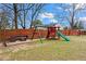 Fenced backyard with a playset, swing set, and seating area, perfect for Gathering fun and relaxation at 2984 Bayard St, East Point, GA 30344