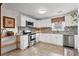 Well-lit kitchen featuring white cabinets, stainless steel appliances, and mosaic tile backsplash at 2984 Bayard St, East Point, GA 30344