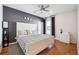 Comfortable bedroom with a gray accent wall, a wooden bed frame, hardwood floors, and plenty of natural light at 2815 Paddle Point Ln, Cumming, GA 30041