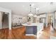 Open-concept kitchen with an island, white cabinets, and stainless steel appliances, seamlessly connected to the dining area at 2815 Paddle Point Ln, Cumming, GA 30041