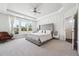 A bright main bedroom with large windows, tray ceilings, and a glimpse into the adjoining bathroom at 2815 Paddle Point Ln, Cumming, GA 30041