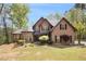Beautiful two-story brick home featuring a manicured lawn and mature trees at 90 Belleview Rdg, Sharpsburg, GA 30277