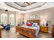 Relaxing main bedroom showcases tray ceiling, sitting area, and wood floors at 90 Belleview Rdg, Sharpsburg, GA 30277