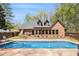 Sparkling in-ground pool with fountain features surrounded by lush landscaping and a charming home exterior at 90 Belleview Rdg, Sharpsburg, GA 30277