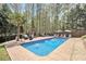 Inviting backyard pool with ample lounging space, lush greenery, and a privacy fence for serene relaxation at 90 Belleview Rdg, Sharpsburg, GA 30277