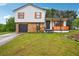Charming two-story home featuring a stone facade, painted wooden shutters, and a covered porch with a wooden railing at 10386 Wisteria Ln, Jonesboro, GA 30238