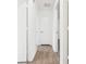 Bright hallway featuring wood-look floors and white doors at 10386 Wisteria Ln, Jonesboro, GA 30238