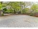 Large gravel backyard with mature trees, partial fencing and detached parking at 1387 Church St, Decatur, GA 30030