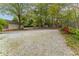 Large gravel backyard area with established trees and perimeter garden at 1387 Church St, Decatur, GA 30030