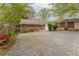 Wide shot of gravel backyard featuring mature trees and a glimpse of adjacent properties at 1387 Church St, Decatur, GA 30030