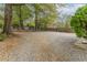 Gravel backyard area featuring established trees and landscaping at 1387 Church St, Decatur, GA 30030