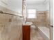 Bathroom featuring beige tiled walls, a tub, a window, and a wood vanity at 1387 Church St, Decatur, GA 30030