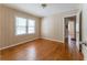 Bedroom featuring light beige-colored walls, a window with blinds, and gorgeous hardwood flooring at 1387 Church St, Decatur, GA 30030