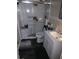 Modern bath features sliding glass door shower, plus single sink with white vanity, dark floors, and chrome hardware at 1774 Pennington Se Pl, Atlanta, GA 30316