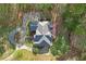 Aerial view of a home with a large driveway and lush, mature landscaping at 240 River Cove Mdws, Social Circle, GA 30025