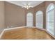 Large bedroom with hardwood floors, arched windows, and neutral tones at 240 River Cove Mdws, Social Circle, GA 30025
