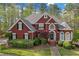 Charming red brick home featuring a manicured lawn, mature trees, and well-maintained landscaping at 240 River Cove Mdws, Social Circle, GA 30025
