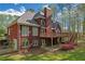 Two-story brick home with deck, patio, manicured lawn, mature trees, and lush landscaping at 240 River Cove Mdws, Social Circle, GA 30025