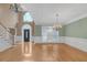 Open-concept living room with hardwood floors, chandelier, and large windows at 240 River Cove Mdws, Social Circle, GA 30025