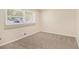Cozy bedroom with neutral carpet, fresh paint, and a window bringing in sunlight at 293 Howell Sw Dr, Atlanta, GA 30331