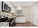 Bright kitchen with white cabinets, granite countertops, and a stainless steel oven at 293 Howell Sw Dr, Atlanta, GA 30331
