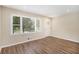 Inviting living room featuring hardwood floors, a large window, and a freshly painted white door at 293 Howell Sw Dr, Atlanta, GA 30331