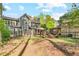 Expansive backyard with mature trees, stone patio, and outdoor fireplace, perfect for entertaining at 3578 Hope Rd, Cumming, GA 30041
