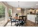 Sun-drenched breakfast nook offers backyard views, wainscoting, and chic lighting fixture at 3578 Hope Rd, Cumming, GA 30041