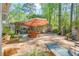 Spacious outdoor patio featuring a dining table, lounge chair, pergola, and a stone fireplace at 3578 Hope Rd, Cumming, GA 30041