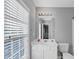 Clean bathroom features a white vanity, large mirror, four light vanity light, and a window for ventilation at 2180 Mill Garden Run, Buford, GA 30519