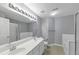 Bright bathroom featuring a double sink vanity, large mirror, and combination tub and shower at 2180 Mill Garden Run, Buford, GA 30519