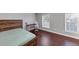 This is a simple bedroom with a wood bedframe, laminate floor, a desk and a window at 2180 Mill Garden Run, Buford, GA 30519
