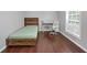 This is a simple bedroom with a wood bedframe, laminate floor, a desk and a window at 2180 Mill Garden Run, Buford, GA 30519
