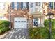 Brick townhome with a white garage door and dark blue front door at 2180 Mill Garden Run, Buford, GA 30519
