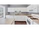 Corner view of a bright kitchen with white cabinets, grey walls, and stainless steel appliances at 2180 Mill Garden Run, Buford, GA 30519