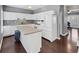 Bright kitchen features an island, white appliances, white cabinets, and dark hardwood floors at 2180 Mill Garden Run, Buford, GA 30519