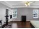 Well-lit main bedroom features tray ceilings, hardwood floors, a ceiling fan, and a fitness bike at 2180 Mill Garden Run, Buford, GA 30519