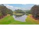 Picturesque aerial view of a pristine golf course featuring a scenic water hazard and meticulously manicured green at 3022 Woodbridge Ln, Canton, GA 30114
